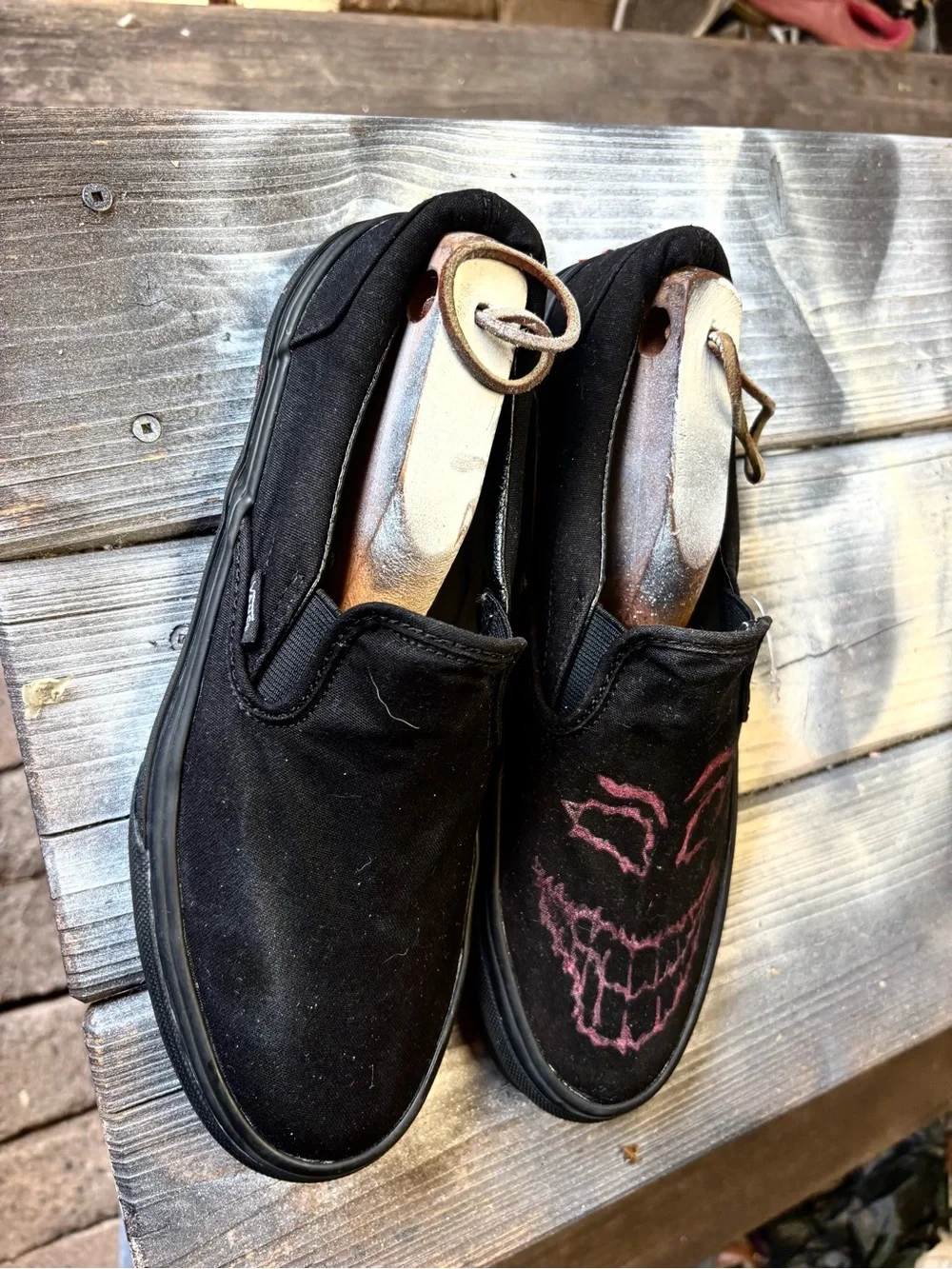 Vans black slip-on canvas sneakers with red hand-painted smiley face
